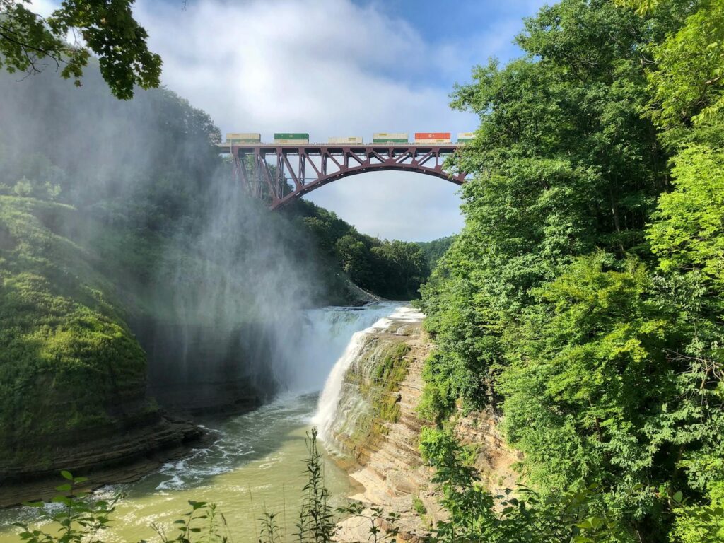 Scenic view of a waterfall and train bridge at Letchworth State Park, NY.