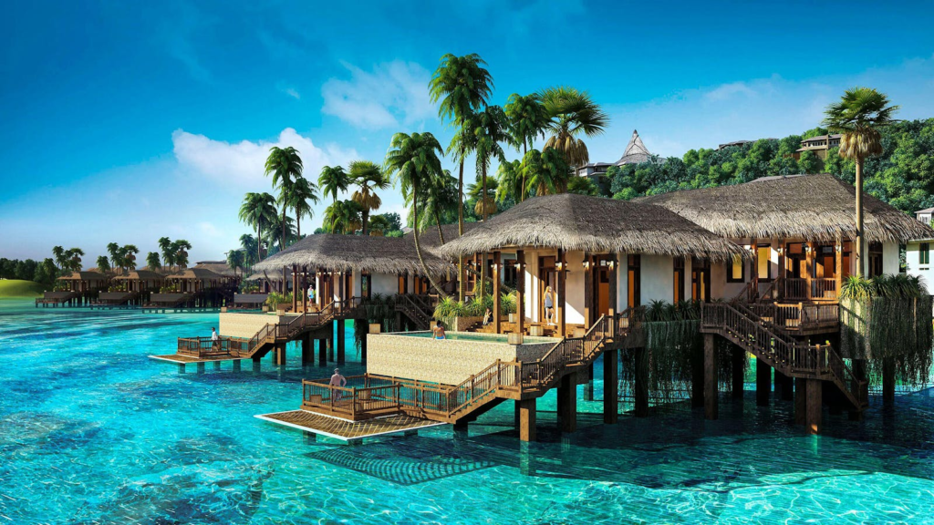 Scenic view of tropical overwater villas surrounded by clear blue water and palm trees in Vietnam.