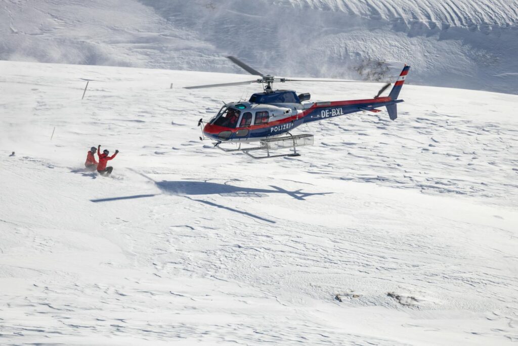 Helicopter executing a police rescue in snowy Heiligenblut mountains.