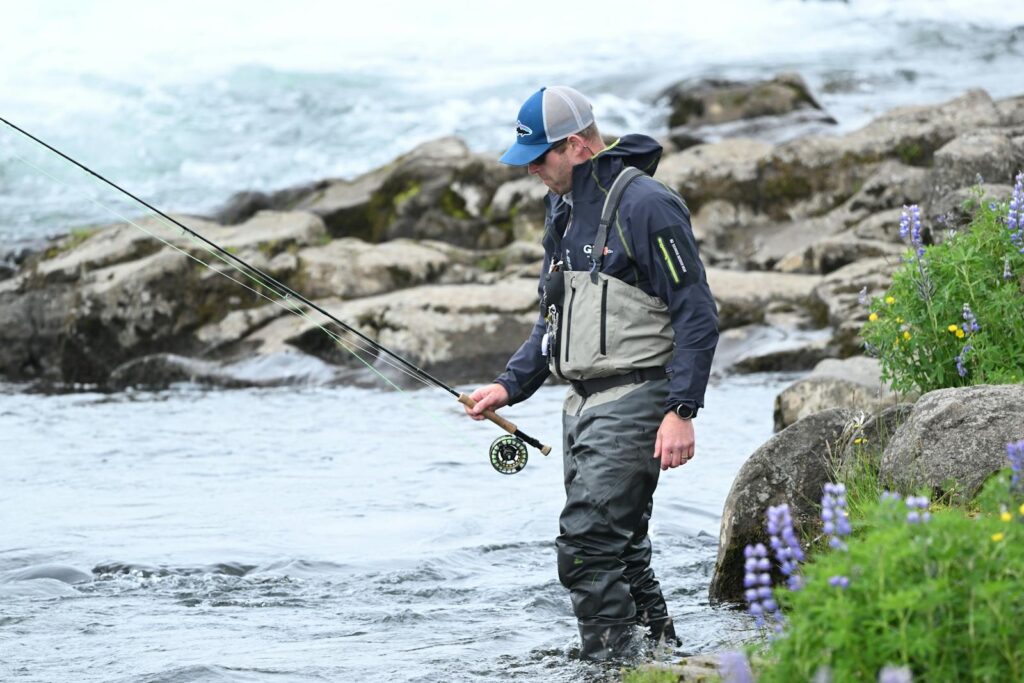 Man wading in river fly fishing near Reykjavík, capturing outdoor adventure and tranquility.