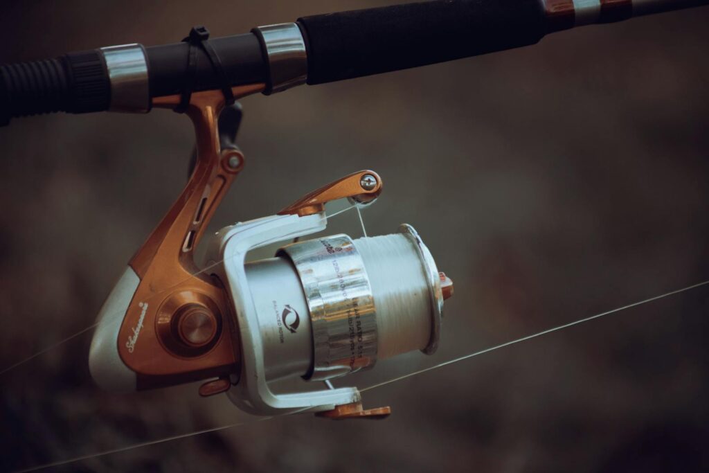 Detailed view of a fishing reel with line tension, showcasing precise fishing equipment mechanics.