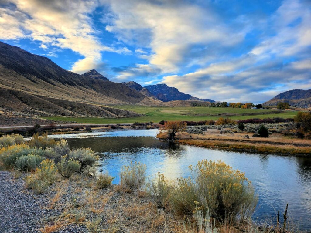 Beautiful river with mountains and autumn foliage under a vibrant sky.