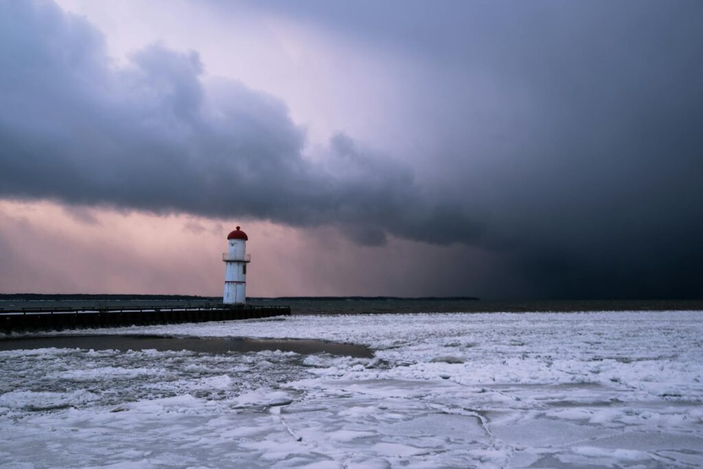 Lighthouse on an icy shore during a winter storm in Montreal, Quebec.