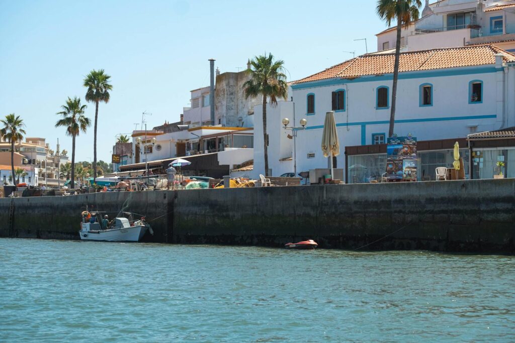 Scenic view of buildings and boat along the waterfront in Faro District, Portugal.