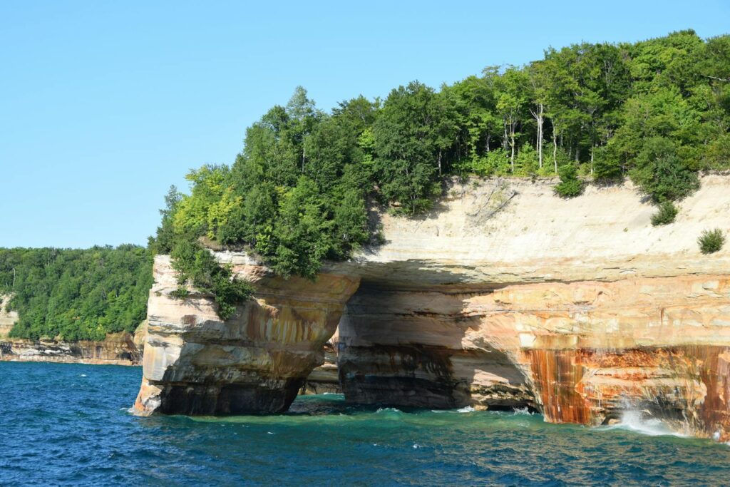 Stunning view of Pictured Rocks' colorful cliffs and green trees by Lake Superior.