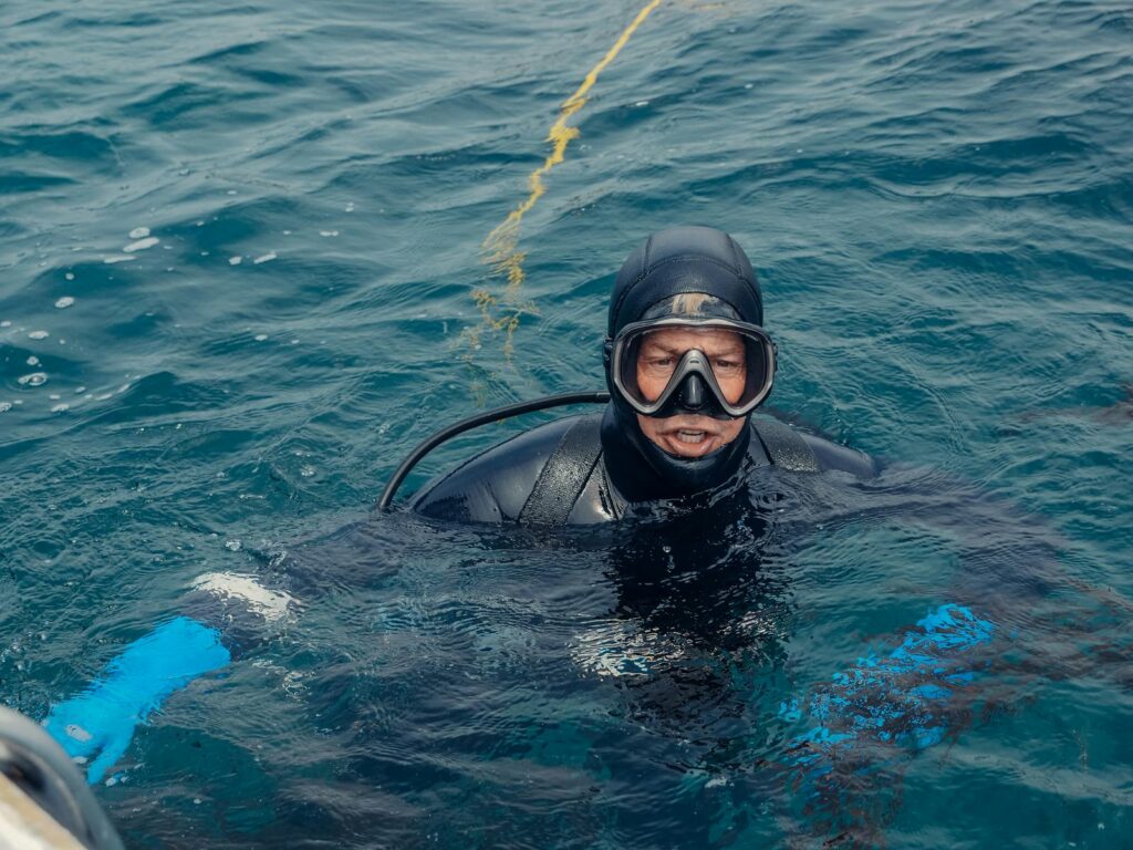 A diver in scuba gear explores ocean waters, showcasing marine adventure.