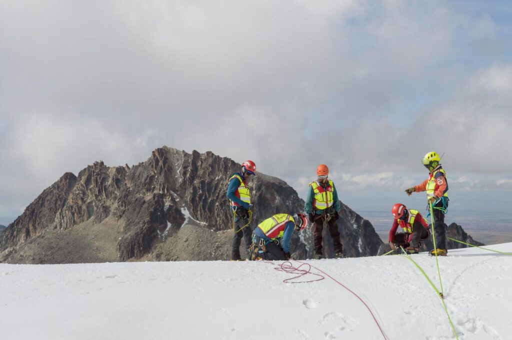 A group of climbers in safety gear conducting a winter mountain expedition.