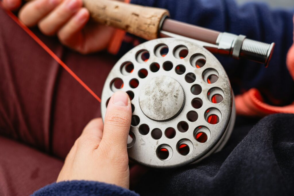a person holding a fishing rod and a fishing reel