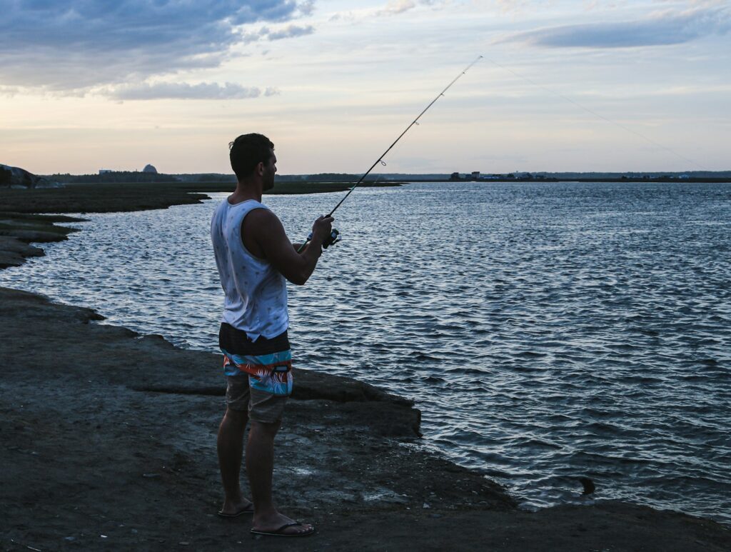 man fishing on rocky shore