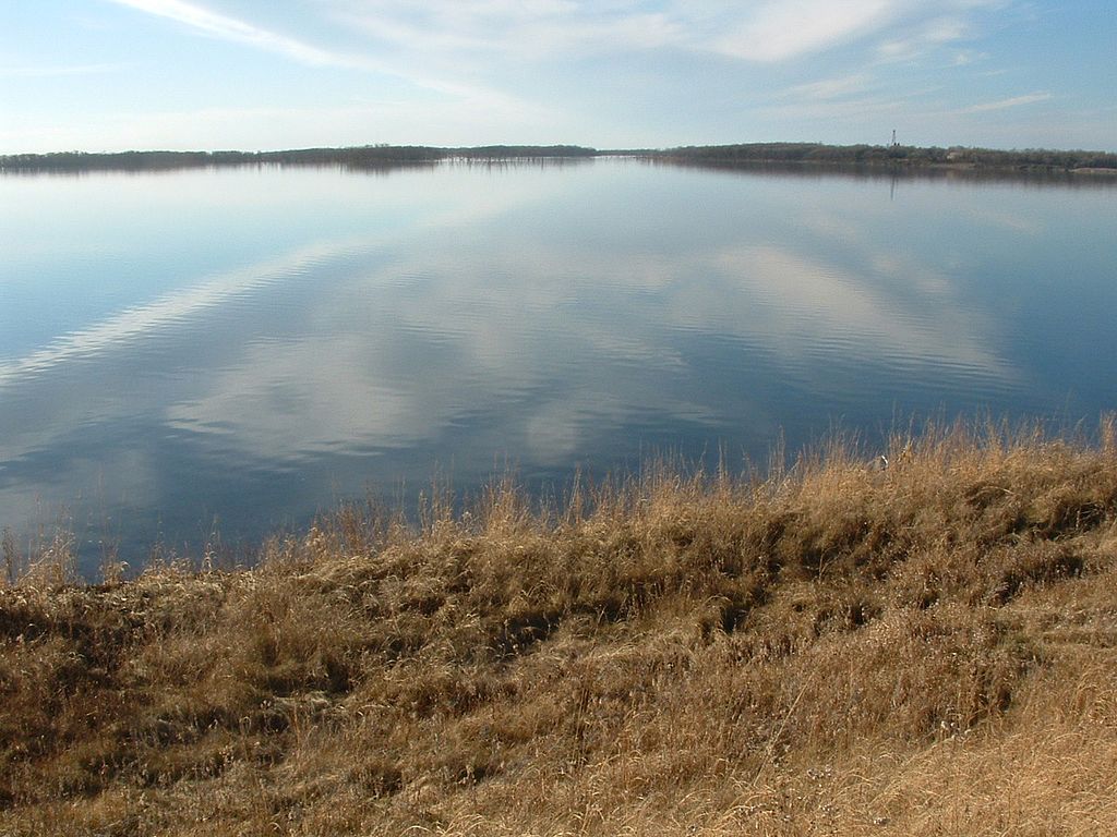 Wind is almost a constant in South Dakota. Once in a while a windless day shows the beauty of the clouds reflecting in the perfectly calm waters at Waubay NWR. View is from the east side of the Refuge looking northwest towards Headquarters.