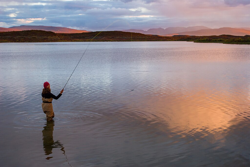An angler fly-fishes at dusk at Tangle Lakes, Alaska.