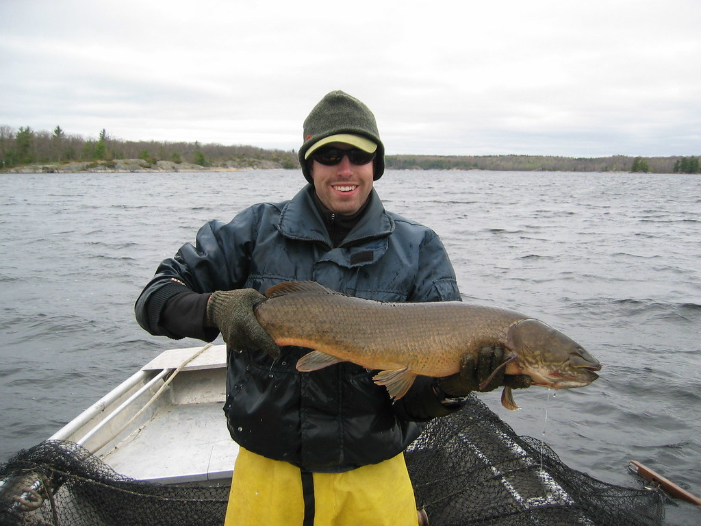 A man holding up his catch: a bowfin