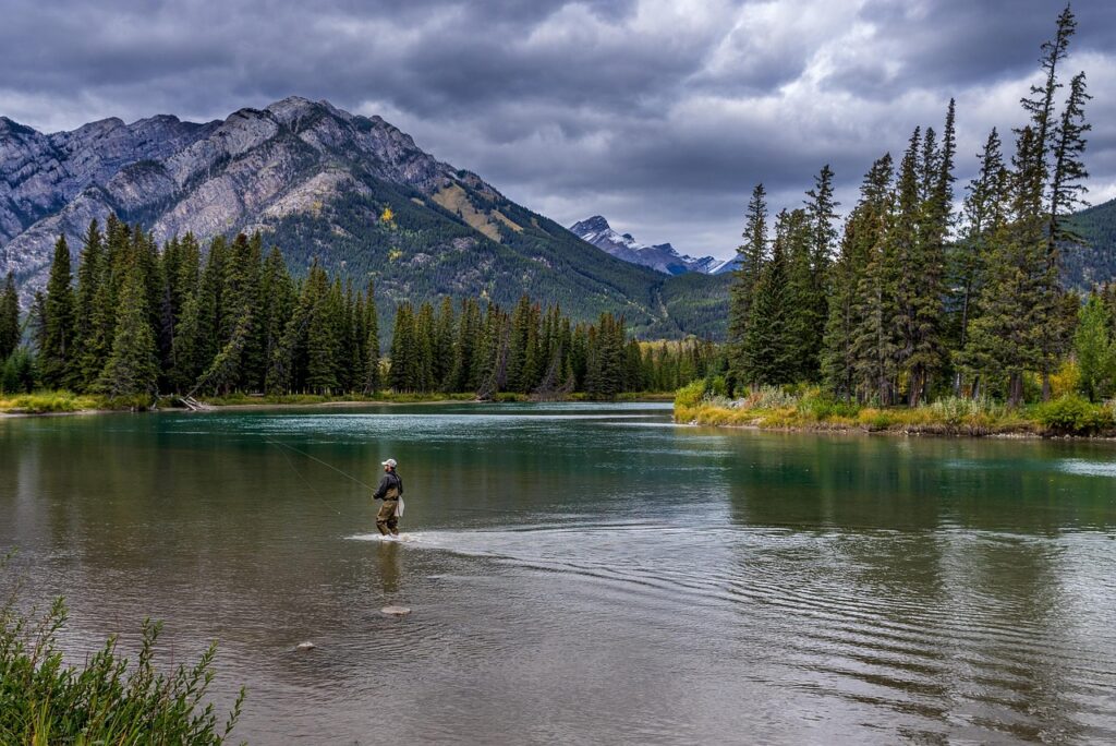 Man wading in the river to fish.