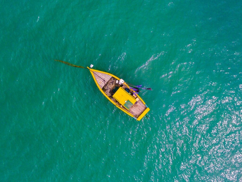 Aerial view of an anchored rowboat on a body of water.