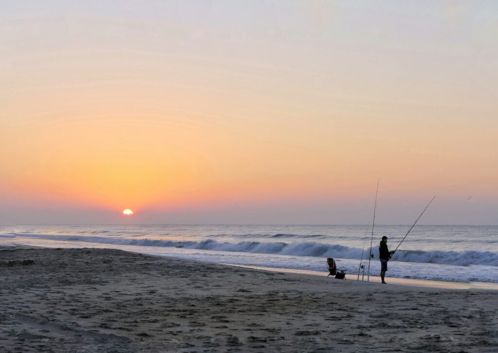 A person standing on top of a sandy beach.