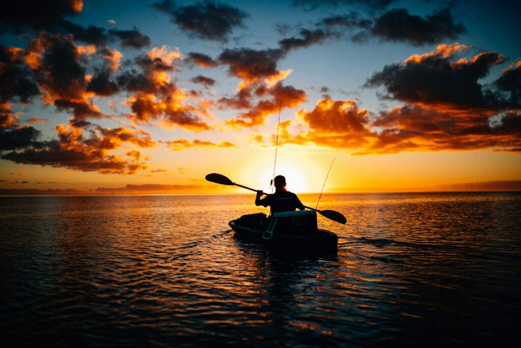 Silhouette of person paddle fishing.
