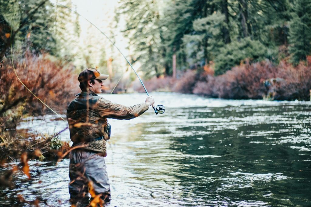 A man fly fishing during the day.