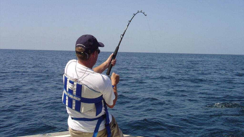 Man deep-sea fishing from a boat