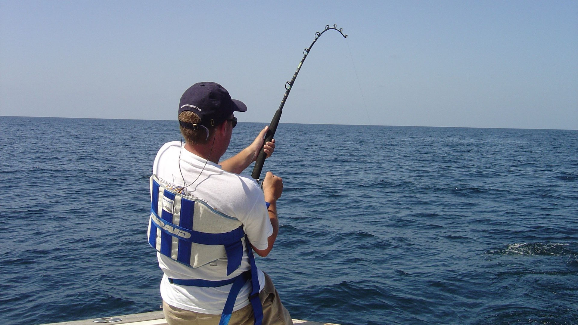 Man deep-sea fishing from a boat