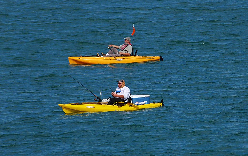 Two people are fishing in kayaks.