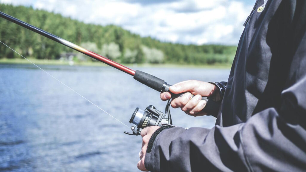A man enjoys fishing at a lake.