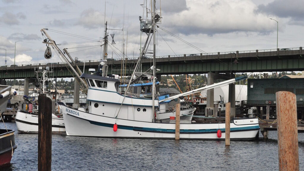 A large commercial fishing boat moored at a Pacific Northwest harbor.