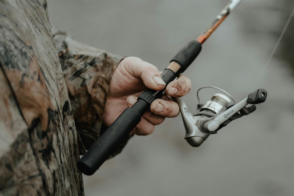 A person holding a fishing rod and a fishing pole.
