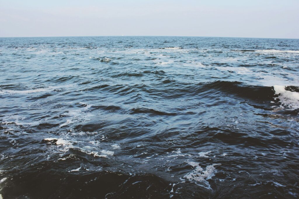 Calm body of water under blue sky during daytime.