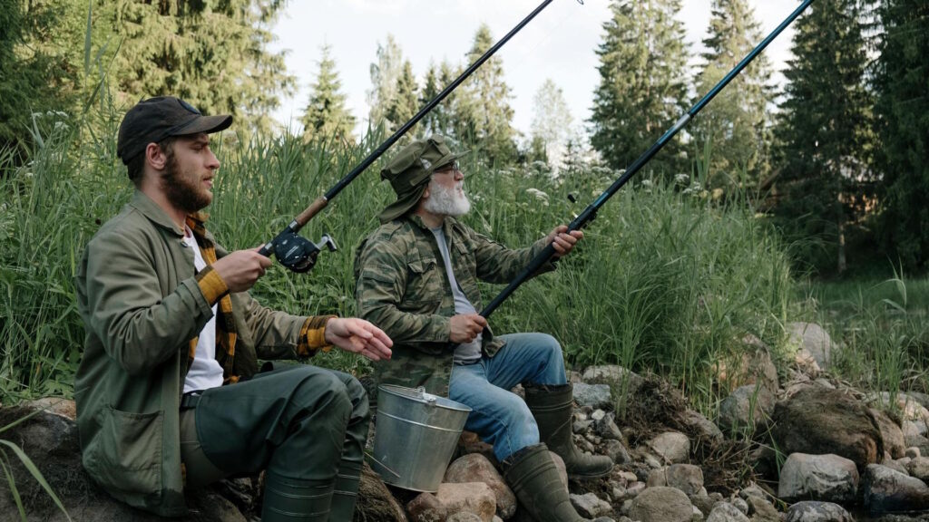 Two men enjoying a peaceful fishing trip by a scenic lake in summer.