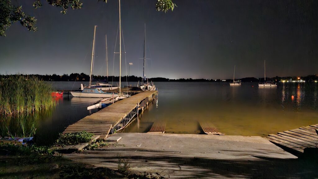 Boats are docked at a dock at night