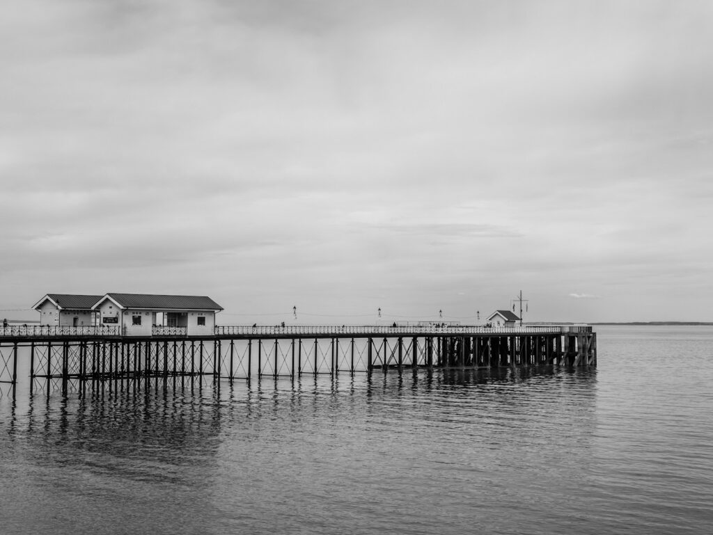 A black-and-white photo of a wooden dock.