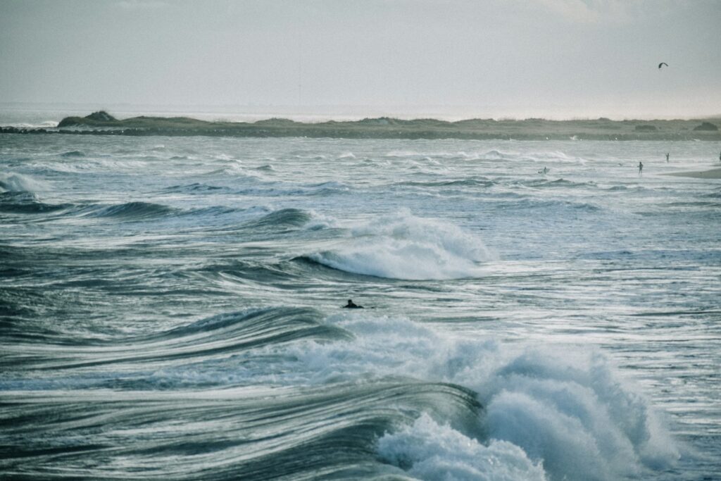 Ocean waves under white sky during daytime.