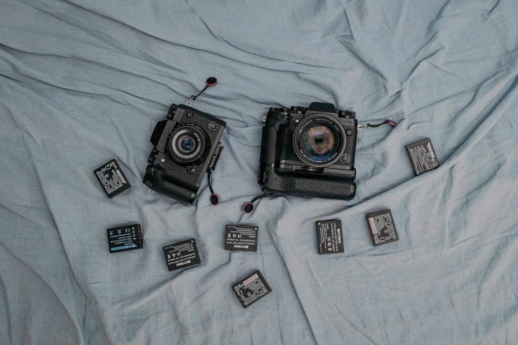a couple of cameras sitting on top of a bed