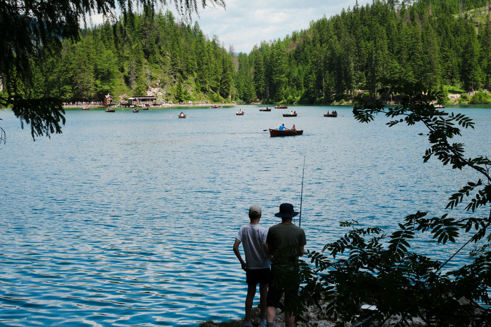 A couple of men standing next to a lake