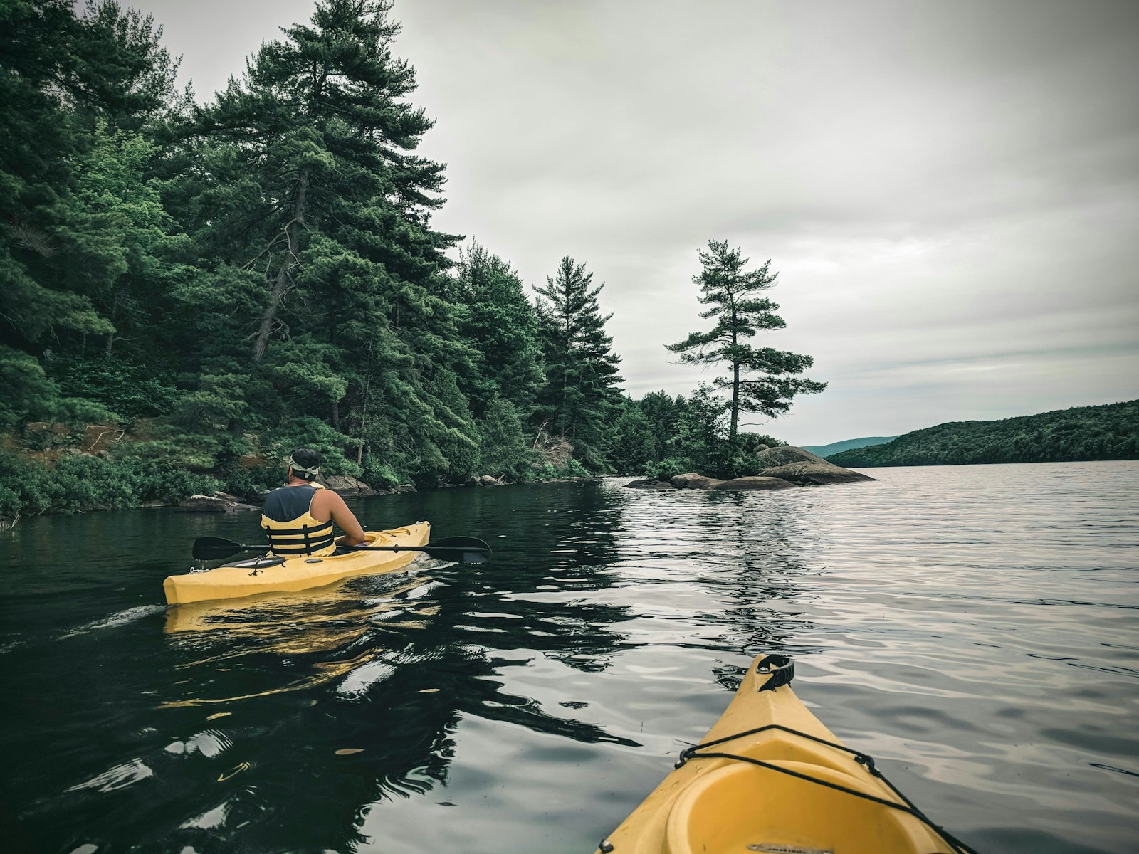 A person riding yellow kayak on lake during daytime.