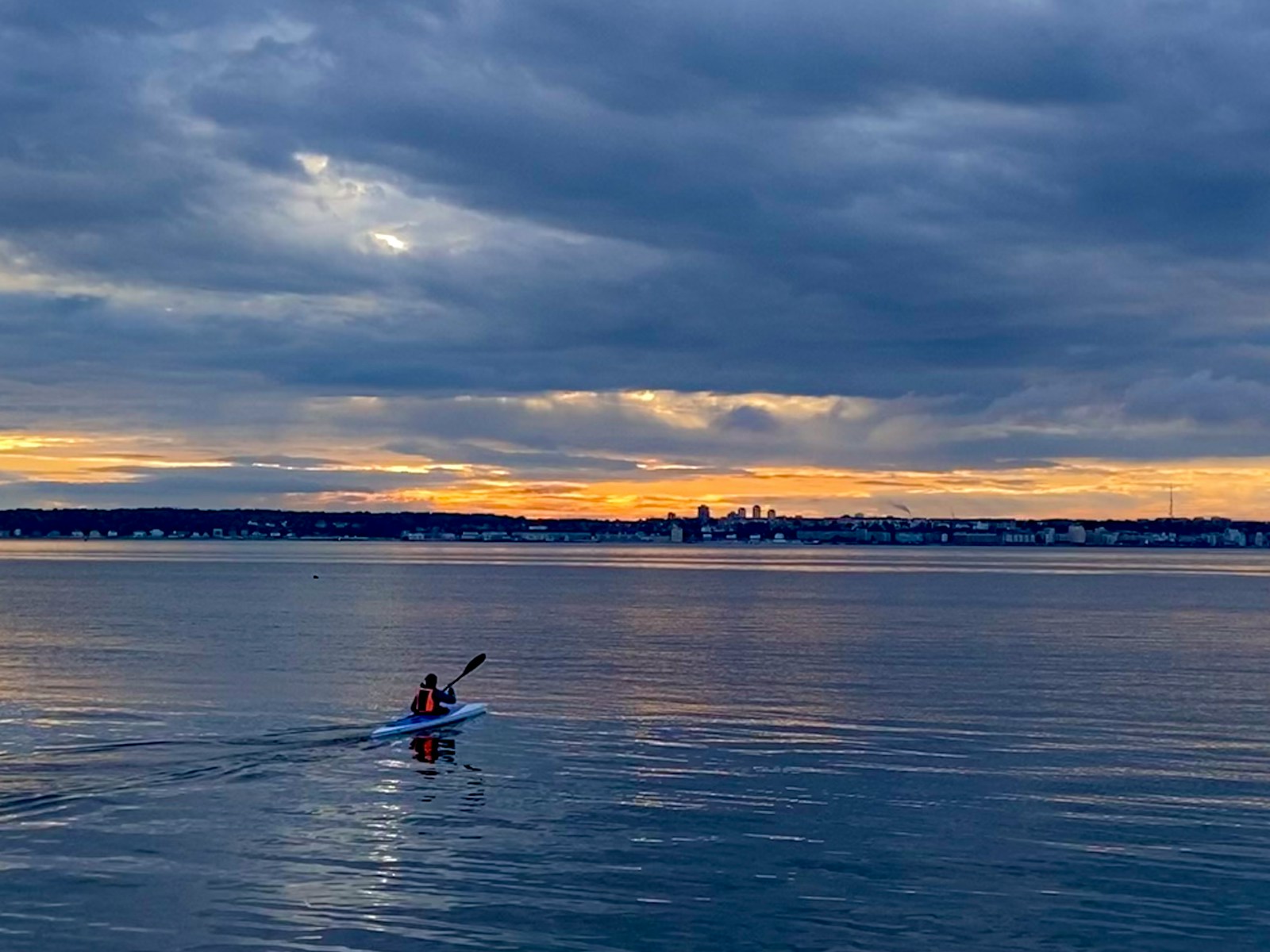 A person in a kayak in the middle of a body of water.